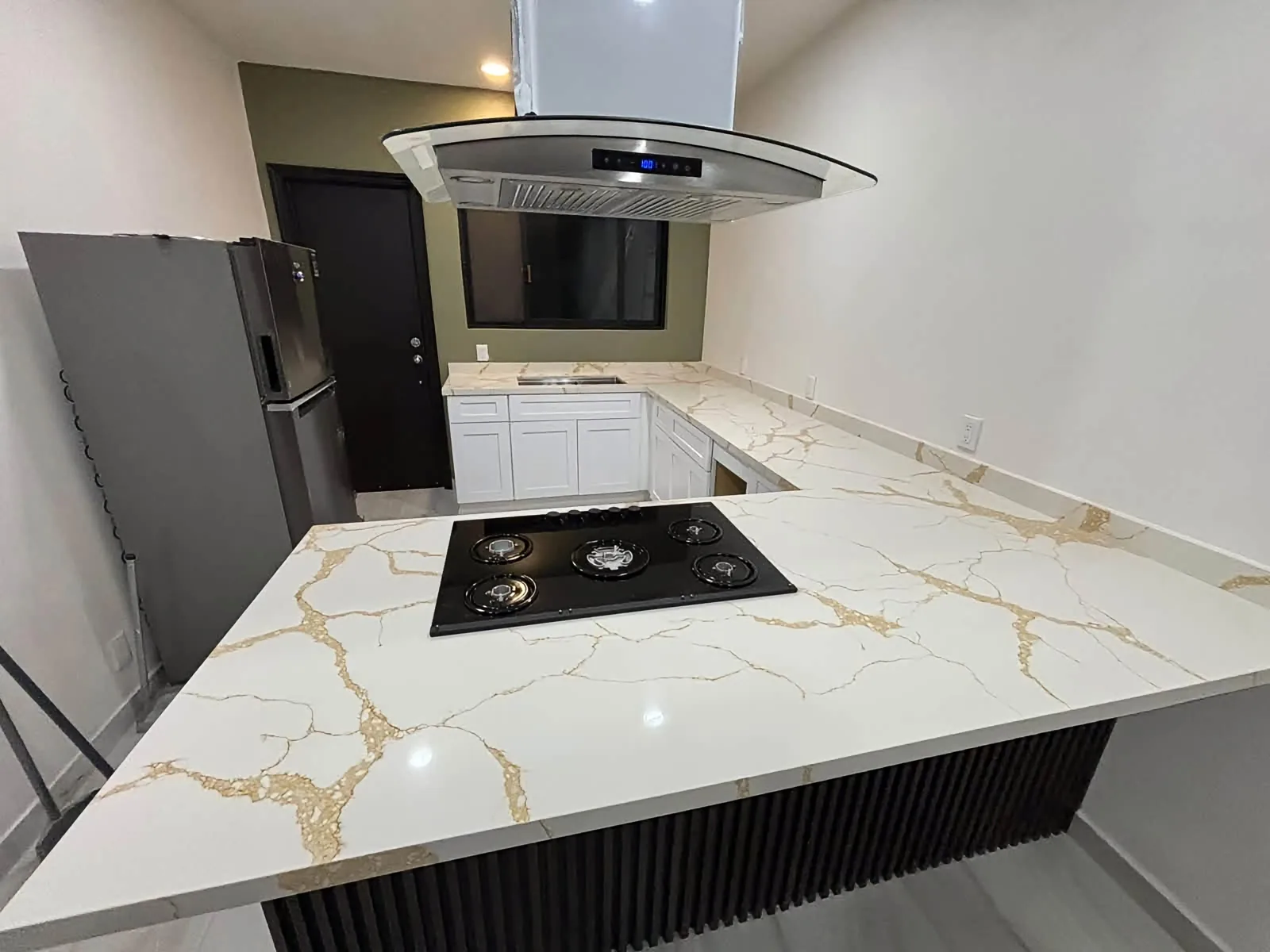 Cocina con isla de superficie blanca veteada